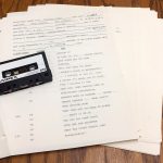 View of typed transcript on white paper with tape cassette